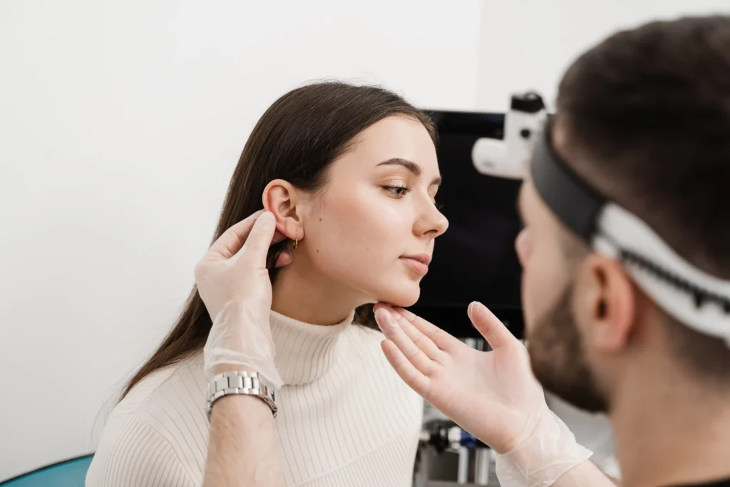 Pharmacist examining a patient’s ear in a clinical setting