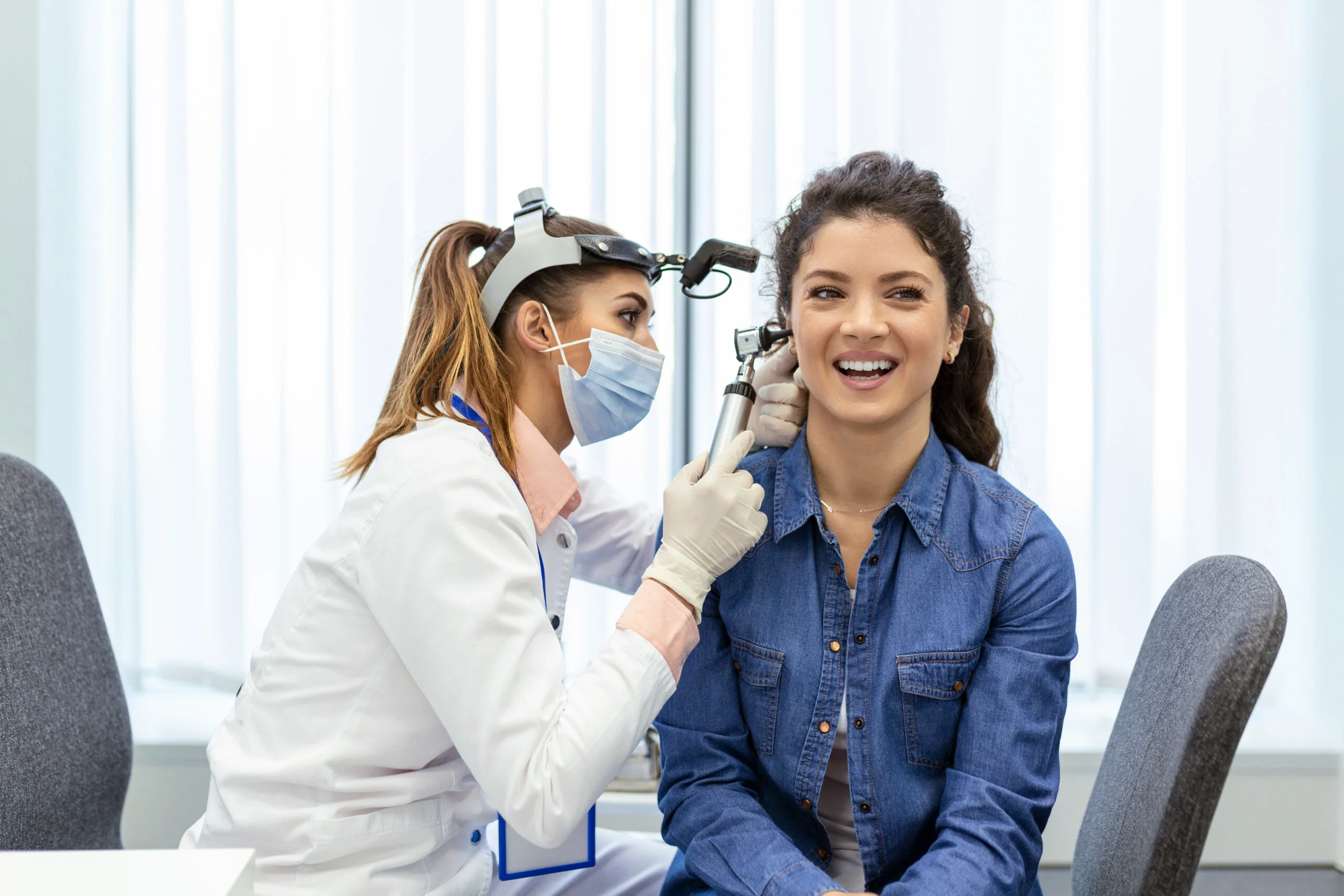 Healthcare professional performing ear examination with otoscope at Yatton Pharmacy in Yatton, Bristol