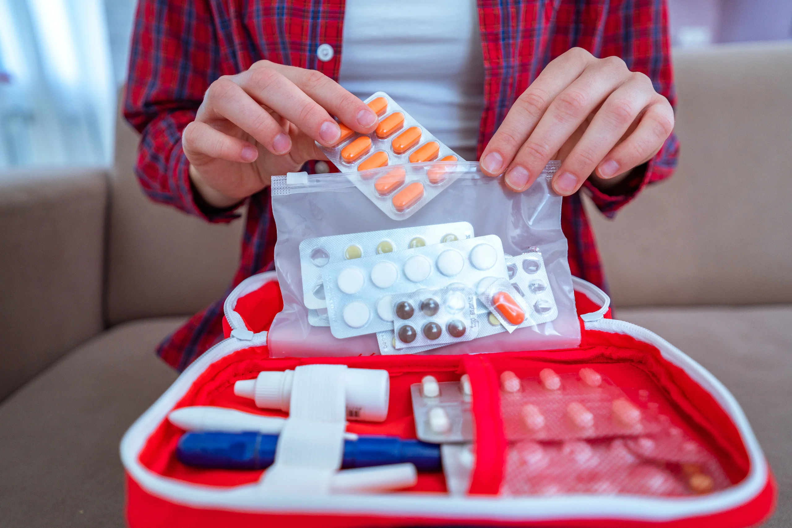 Person organizing first aid kit with medical supplies at Yatton Pharmacy in Yatton, Bristol
