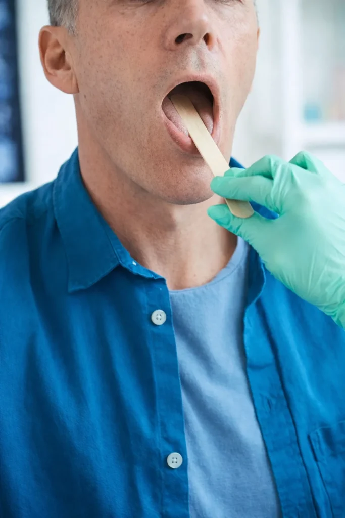Doctor examining throat with depressor