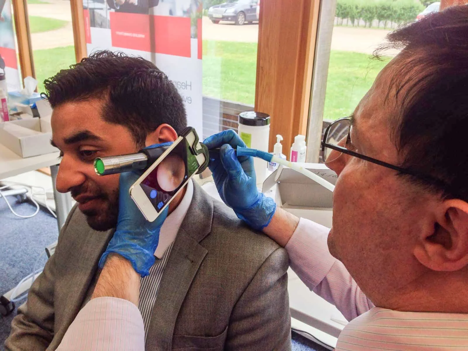 Ear examination using smartphone otoscope device at Yatton Pharmacy in Yatton, Bristol