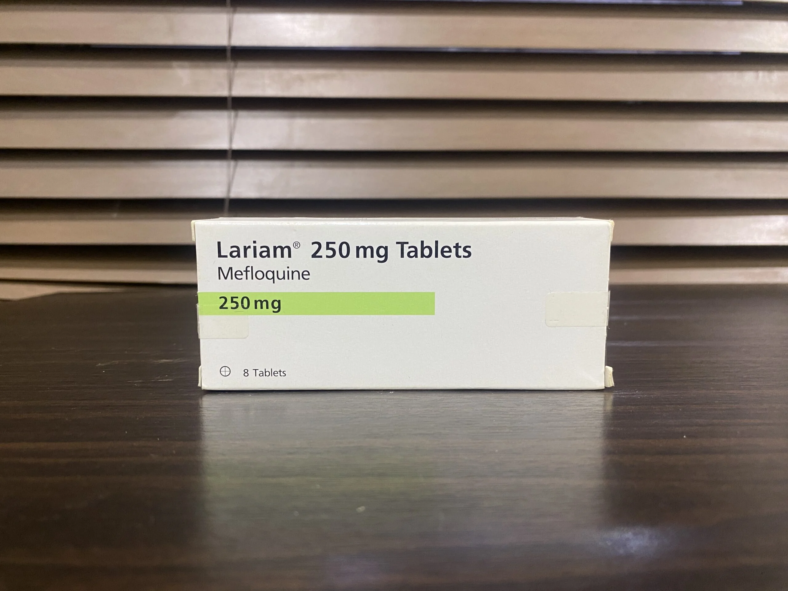 Box of Lariam 250 mg tablets containing mefloquine for malaria prevention, placed on a wooden surface.