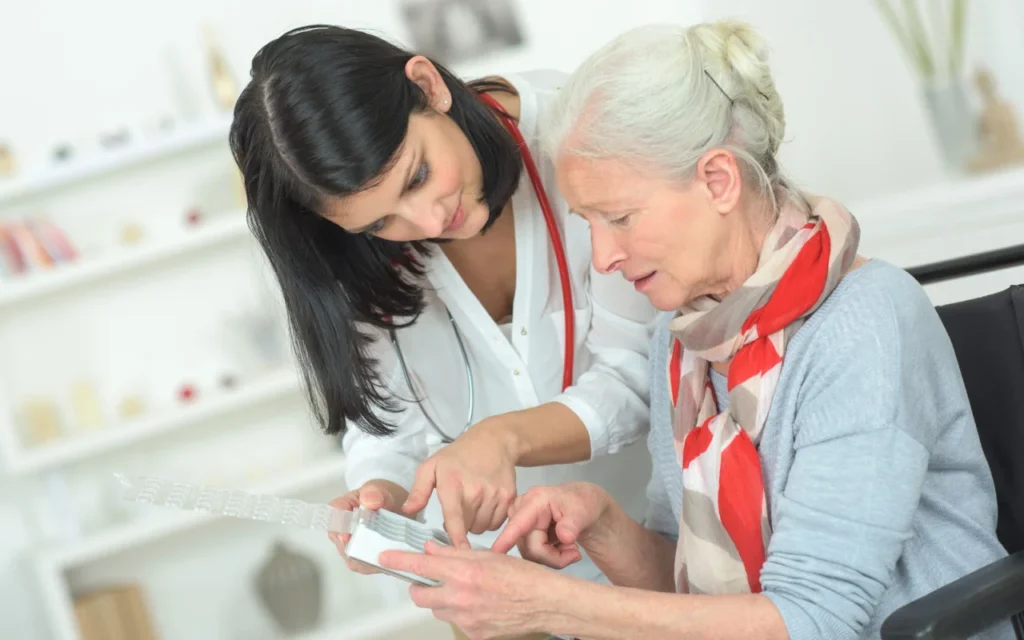 Doctor guiding older adult with pill organizer at Yatton Pharmacy in Yatton, Bristol