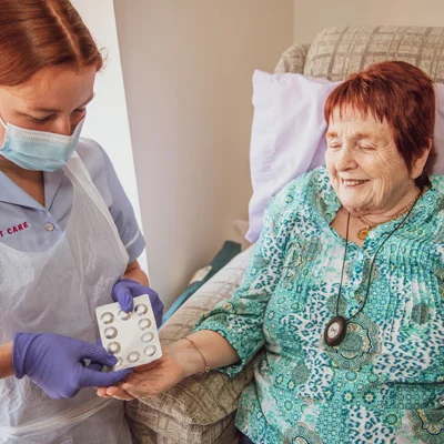 Healthcare worker assisting older adult with medication at Yatton Pharmacy in Yatton, Bristol