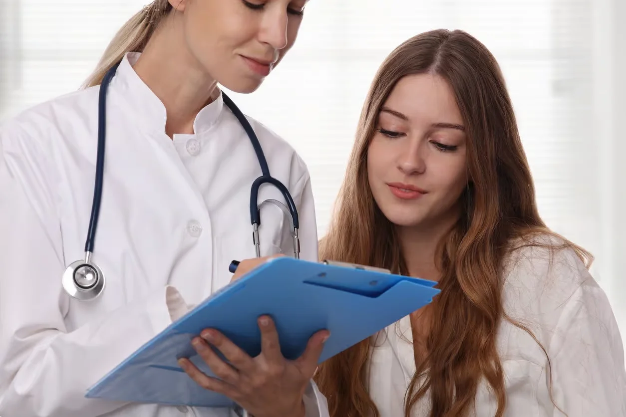Doctor reviewing patient information on clipboard at Yatton Pharmacy in Yatton, Bristol